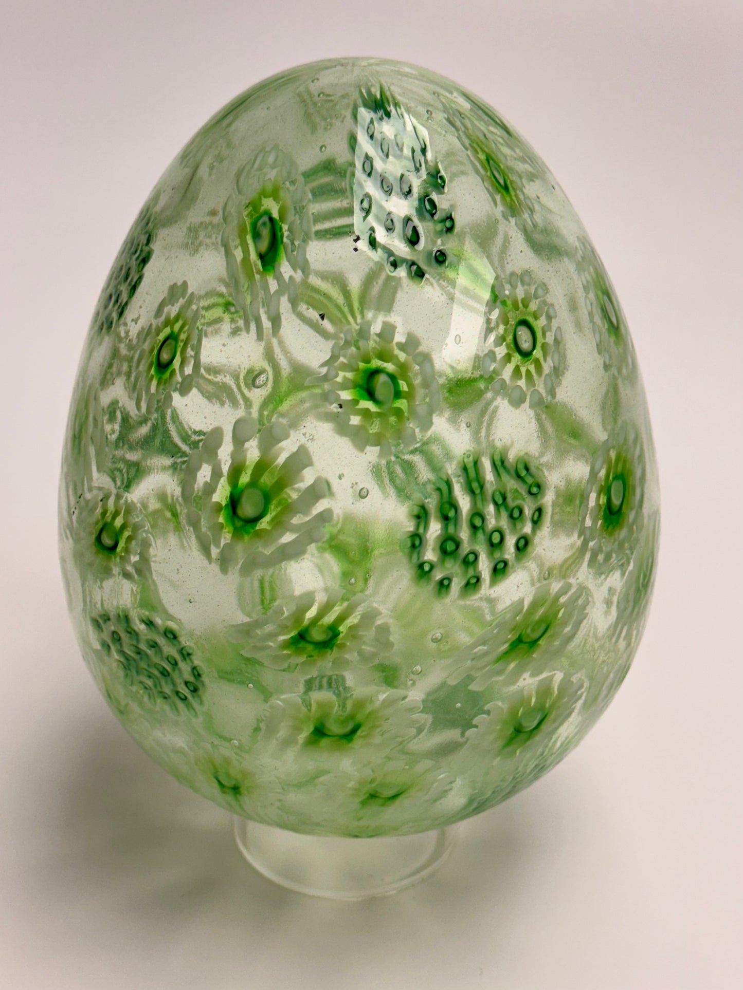 Green, white, and clear “jeweled" seven-inch egg. Handblown murrine glass art.